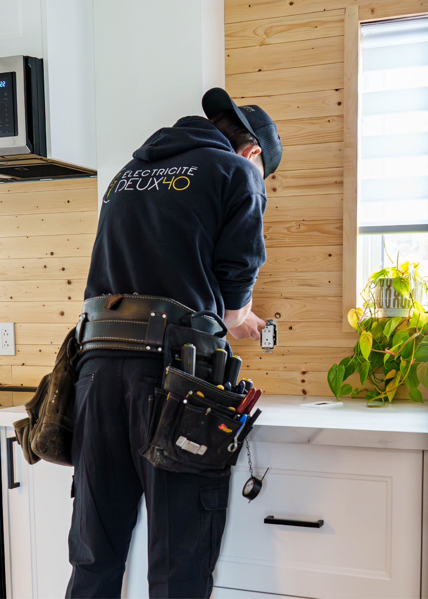 Électricien remplaçant une prise électrique dans une maison